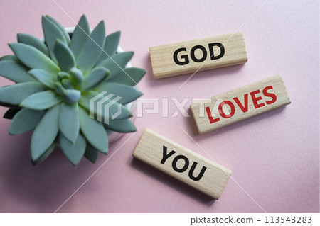 God loves you symbol. Wooden blocks with words God loves you. Beautiful pink background with succulent plant. Religion and God loves you concept. Copy space. God loves you symbol. Wooden blocks with words God loves you. Beautiful pink background with succulent plant. Religion and God loves you concept. Copy space. 113543283