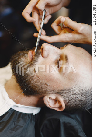 Man with a beard. Hairdresser with a client. Man with a comb and scissors Man with a beard. Hairdresser with a client. Man with a comb and scissors 113545091