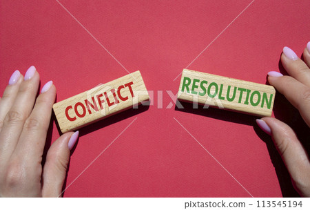 Conflict or Resolution symbol. Concept word Conflict or Resolution on wooden blocks. Businessman hand. Beautiful red background. Business and Conflict or Resolution concept. Copy space 113545194