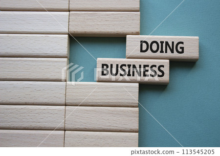 Doing Business symbol. Concept word Doing Business on wooden blocks. Beautiful grey green background. Business and Doing Business concept. Copy space Doing Business symbol. Concept word Doing Business on wooden blocks. Beautiful grey green background. Business and Doing Business concept. Copy space 113545205