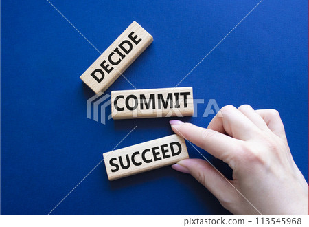 Decide Commit Succeed symbol. Concept words Decide Commit Succeed on wooden blocks. Businessman hand. Beautiful deep blue background. Business concept. Copy space. 113545968