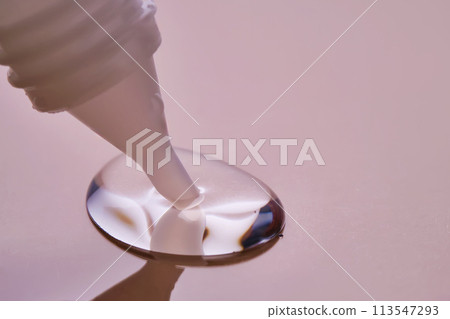 Stationery glue flows onto pink paper. Stationery glue flows onto pink paper. 113547293