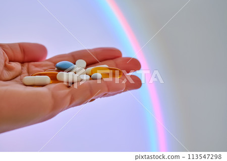 Vitamins and dietary supplements on the palm against the luminous circle. 113547298