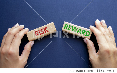 Risk or Reward symbol. Concept word Risk or Reward on wooden blocks. Businessman hand. Beautiful deep blue background. Business and Risk or Reward concept. Copy space Risk or Reward symbol. Concept word Risk or Reward on wooden blocks. Businessman hand. Beautiful deep blue background. Business and Risk or Reward concept. Copy space 113547603