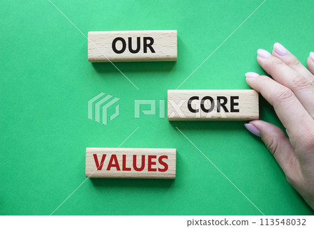 Our core values symbol. Concept words Our core values on wooden blocks. Beautiful green background. Businessman hand. Business and Our core values concept. Copy space. Our core values symbol. Concept words Our core values on wooden blocks. Beautiful green background. Businessman hand. Business and Our core values concept. Copy space. 113548032