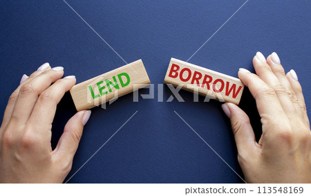 Lend or Borrow symbol. Concept word Lend or Borrow on wooden blocks. Businessman hand. Beautiful deep blue background. Business and Lend or Borrow concept. Copy space 113548169