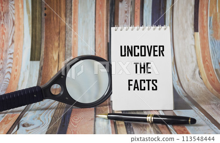 Uncover the facts with text on a notepad, near a magnifying glass and pen on a vintage background Uncover the facts with text on a notepad, near a magnifying glass and pen on a vintage background 113548444