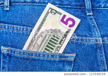 Banknote of five american dollars sticking out of the jeans pocket 113549159