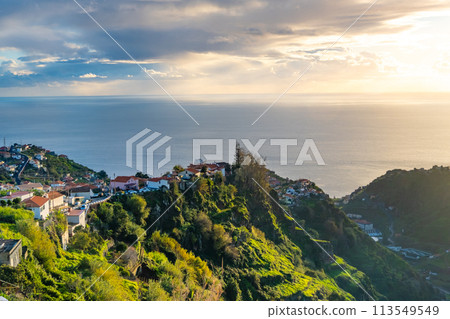Taditional Madeiran houses in Funchal behind a banana plantation and ocean sunset. Taditional Madeiran houses in Funchal behind a banana plantation and ocean sunset. 113549549