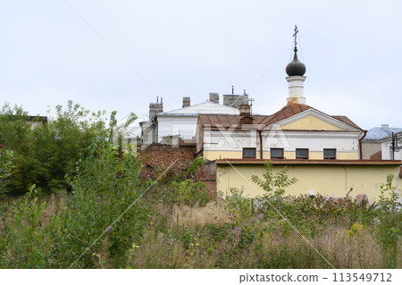 A wasteland overgrown with grass, a brick wall and an old church in Rybinsk, Russia A wasteland overgrown with grass, a brick wall and an old church in Rybinsk, Russia 113549712