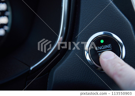 Man presses the engine start button in a car Man presses the engine start button in a car 113550903