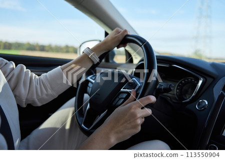Inside view of woman driving car on countryside road Inside view of woman driving car on countryside road 113550904