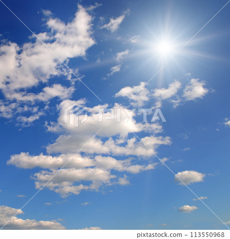 Bright sun on blue cloudy sky. 113550968