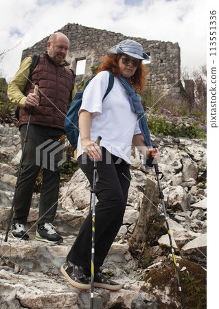 senior couple hiking outdoor, man and woman norwegian walking with sticks landscape senior couple hiking outdoor, man and woman norwegian walking with sticks landscape 113551336
