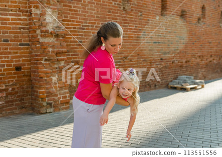 Child girl with cochlear implant with her mother spend time outdoor. Hear impairment and deaf community concept. Deaf and health concept. Diversity and inclusion. Copy space Child girl with cochlear implant with her mother spend time outdoor. Hear impairment and deaf community concept. Deaf and health concept. Diversity and inclusion. Copy space 113551556