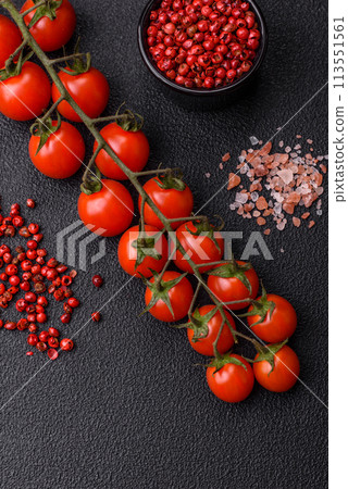A sprig of ripe red cherry tomatoes as an ingredient for cooking at home 113551561