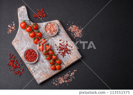 A sprig of ripe red cherry tomatoes as an ingredient for cooking at home A sprig of ripe red cherry tomatoes as an ingredient for cooking at home 113551575