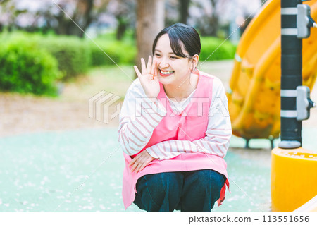 幼兒園老師在公園的遊樂場設備前與孩子們玩耍 幼兒園老師在公園的遊樂場設備前與孩子們玩耍 113551656