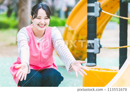 幼兒園老師在公園的遊樂場設備前與孩子們玩耍 113551678