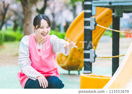 幼兒園老師在公園的遊樂場設備前與孩子們玩耍 113551679
