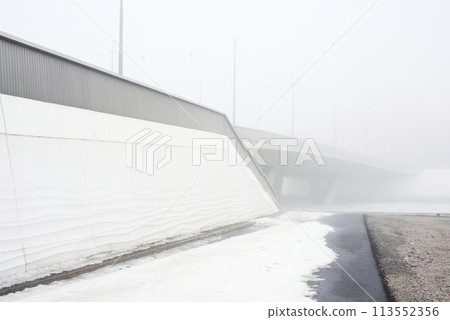 concrete bridge in heavy fog in early spring 113552356
