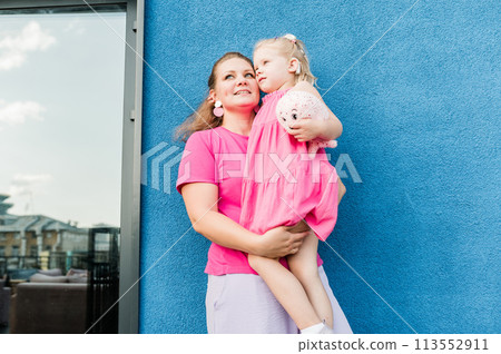 Mother holds and have fun her child with hearing aids and cochlear implants summer outdoor . Deaf and health concept. Diversity and inclusion. Copy space 113552911