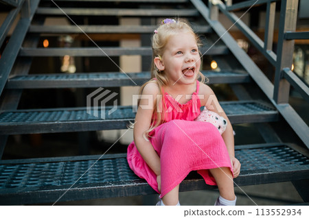 Funny baby with cochlear implant walks outdoor. Hearing aid and medicine innovating technology concept. Diversity and inclusion. Copy space 113552934