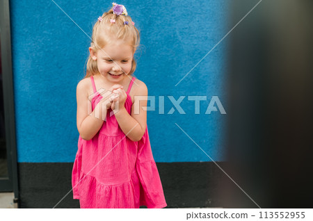 Child girl with hearing aids and cochlear implants having fun outdoor speak and playing. Copy space and empty place for advertising 113552955