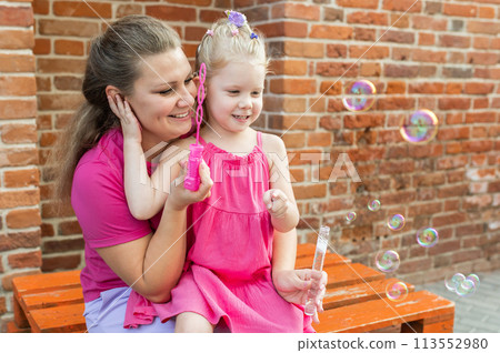 Mother holds and have fun her child with hearing aids and cochlear implants summer outdoor . Deaf and health concept. Diversity and inclusion. Copy space Mother holds and have fun her child with hearing aids and cochlear implants summer outdoor . Deaf and health concept. Diversity and inclusion. Copy space 113552980