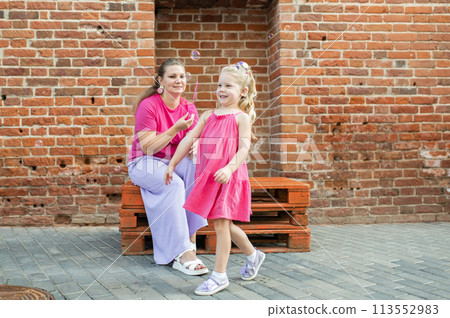 Mother holds and have fun her child with hearing aids and cochlear implants summer outdoor . Deaf and health concept. Diversity and inclusion. Copy space Mother holds and have fun her child with hearing aids and cochlear implants summer outdoor . Deaf and health concept. Diversity and inclusion. Copy space 113552983