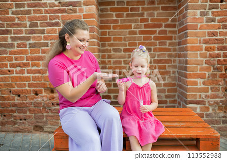 Child girl with cochlear implant with her mother spend time outdoor. Hear impairment and deaf community concept. Deaf and health concept. Diversity and inclusion. Copy space Child girl with cochlear implant with her mother spend time outdoor. Hear impairment and deaf community concept. Deaf and health concept. Diversity and inclusion. Copy space 113552988