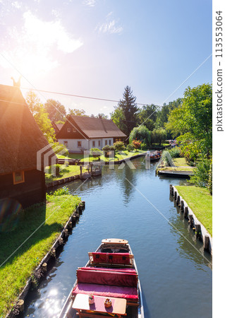 Scenic view of green riverside garden house german national park Spreewald on spring summer sunny day . Spree river forest greenery canal nature tranquil landscape in Germany blue sky background Scenic view of green riverside garden house german national park Spreewald on spring summer sunny day . Spree river forest greenery canal nature tranquil landscape in Germany blue sky background 113553064