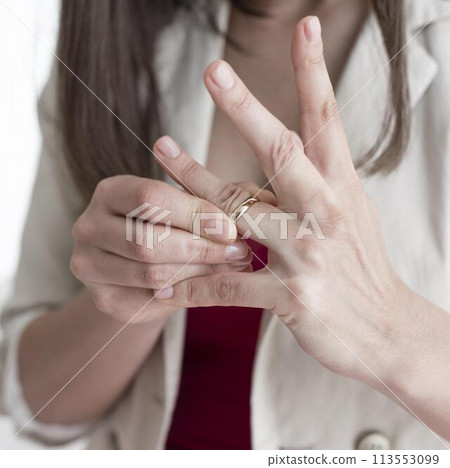 Close-up woman taking wedding ring off finger Close-up woman taking wedding ring off finger 113553099