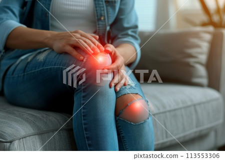 Close-up of a woman holding her painful knee, depicting symptoms of arthritis 113553306
