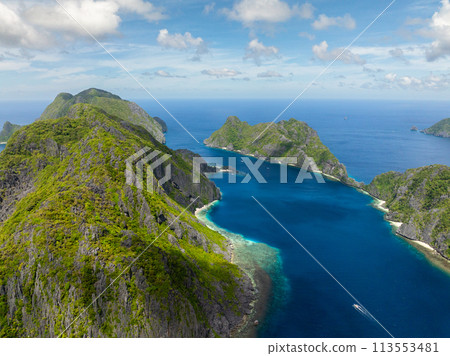 Tapiutan Island and Matinloc Island with boa over blue sea. El Nido, Palawan. Philippines. 113553481