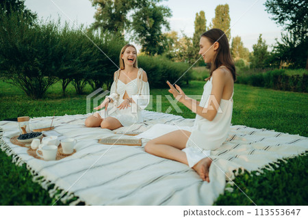 Two young women meditate and do yoga in nature. Two young women meditate and do yoga in nature. 113553647