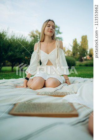 Meditation and nailing. Two young women are meditating in nature. 113553662