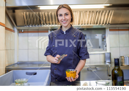 Smiling young cooker in the kitchen looking busy 113554190