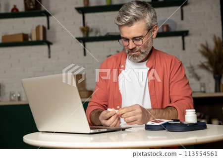 Diabetic man getting online consultation on laptop at home Diabetic man getting online consultation on laptop at home 113554561