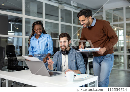 Group of professionals collaborating and using laptop in coworking environment 113554714