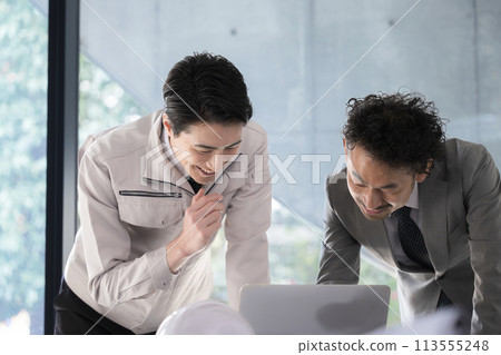 Site supervisor and construction management engineer checking construction drawings 113555248