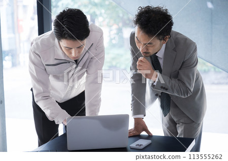 Site supervisor and construction management engineer checking construction drawings. A businessman thinking and worrying about building design and construction management. 113555262