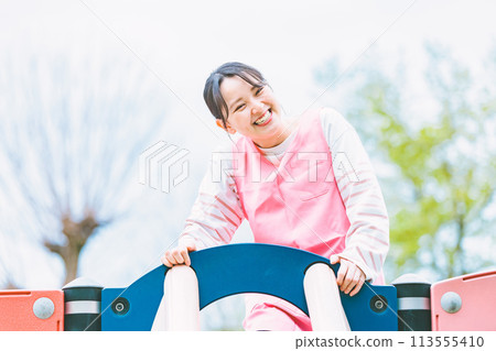 幼兒園老師和孩子們在公園的遊樂場設備上玩耍 113555410