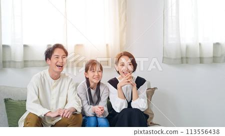 Parents and children happy while watching TV in the living room Parents and children happy while watching TV in the living room 113556438