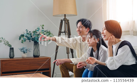 Parent and child watching TV in the living room Parent and child watching TV in the living room 113556439