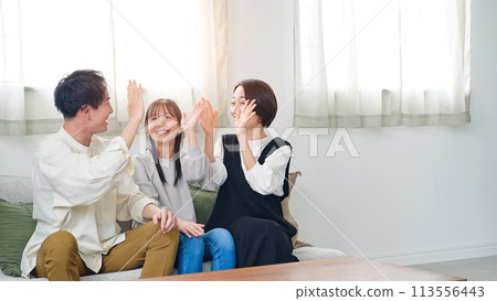 Parents and children happy while watching TV in the living room Parents and children happy while watching TV in the living room 113556443
