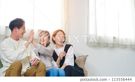 Parents and children happy while watching TV in the living room 113556444