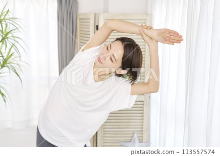 A woman in her 40s stretching at home 113557574