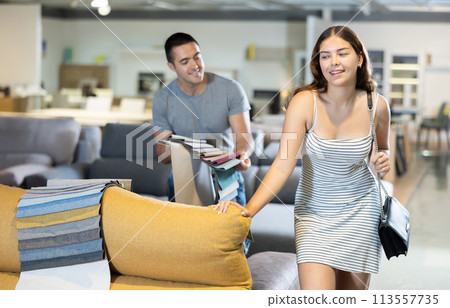 Man with his girlfriend are choosing modern materials for furniture for their home in furniture store 113557735