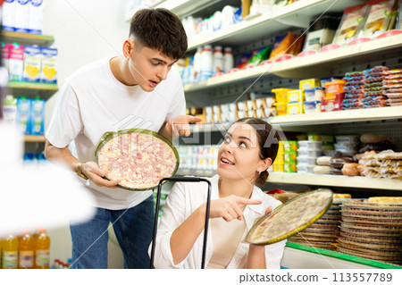 Young couple choosing delicious frozen pizza in supermarket 113557789
